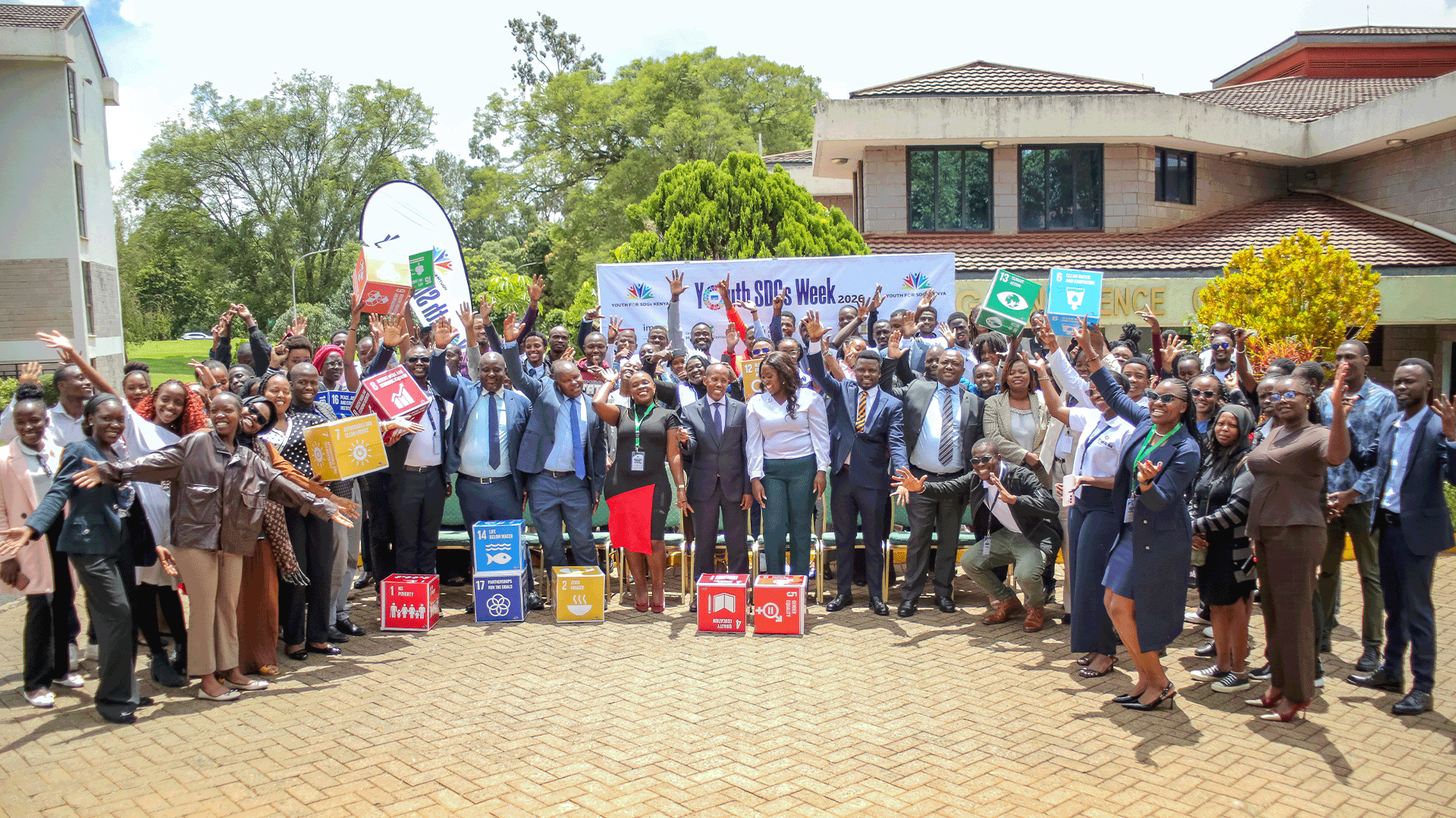 Group photo of Youth for SDGs Week 2026 participants gathered outdoors in Nairobi, Kenya, holding SDG-themed signs.