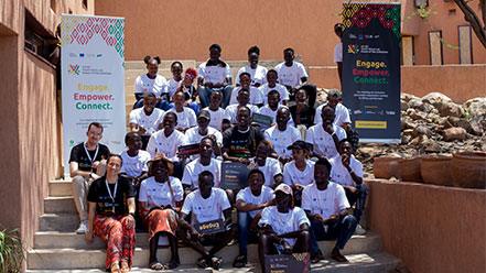 Young people sitting down, smiling, and facing the camera