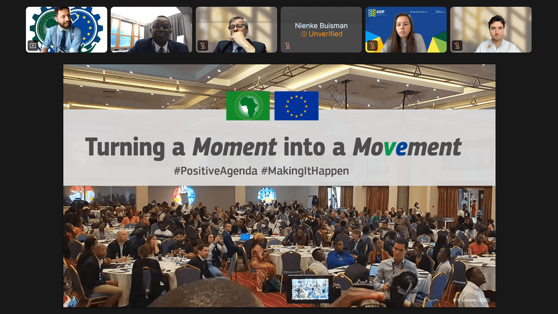 Webinar view showing attendees and a large conference room with many attendees seated at round tables; a banner reads "Turning a Moment into a Movement" with African Union and EU logos above.